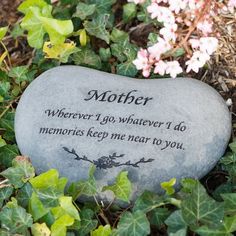 a memorial stone sitting in the grass next to some flowers and leaves with a poem written on it