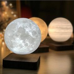 the moon lamp is sitting on top of a wooden block