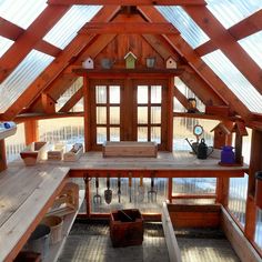 the inside of a small wooden building with lots of windows and wood shelves on each side