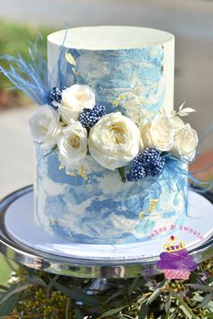 there is a blue and white cake with flowers on it