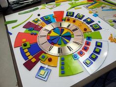 a colorful clock sitting on top of a table covered in magnets and colored papers