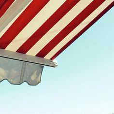 an american flag is hanging on the side of a building with blue sky in the background