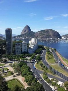 an aerial view of a city with mountains in the background and cars driving on the road