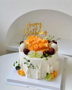 a birthday cake with cheese and fruit on top