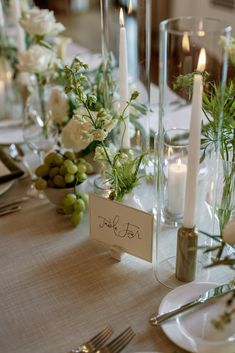 the table is set with candles, flowers and place cards for guests to write on