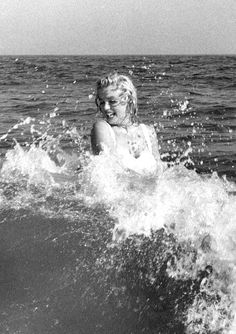 a young boy riding a wave on top of a surfboard in the middle of the ocean