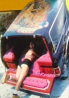 a woman laying on top of a couch in the back of a bus