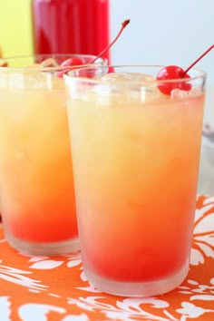 two glasses filled with drinks sitting on top of a table