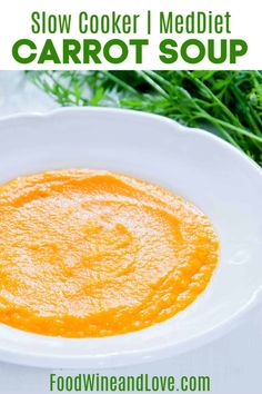 a white bowl filled with carrot soup on top of a table