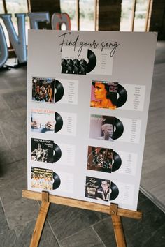 a sign that is on top of a wooden easel with vinyl records attached to it