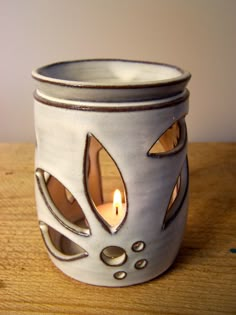 a candle is lit in a ceramic cup