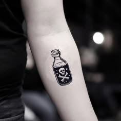 a bottle with a skull and crossbones tattoo on the left inner arm is shown