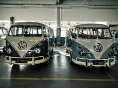 three vw buses are parked in a garage