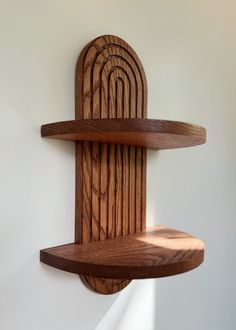 two wooden shelves on the wall, one with a curved shelf and one with an oval shelf