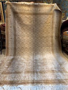 an old blanket is on display in a room full of antique furniture and rugs