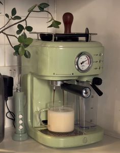 an espresso machine sitting on top of a counter next to a glass of milk