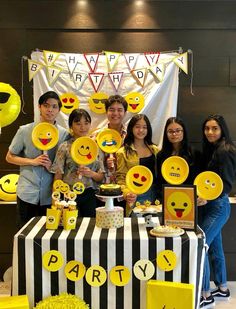 a group of people standing next to each other in front of a table with plates