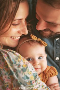 A smiling mother and father embrace their adorable baby, who wears a cute bow, capturing a moment of family love and joy.