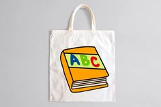 a tote bag with an abc book on the front, and letters on the back