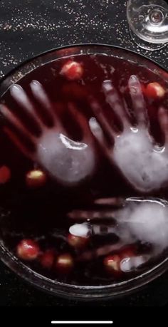 an image of someones hand in water with bubbles on it and some wine glasses