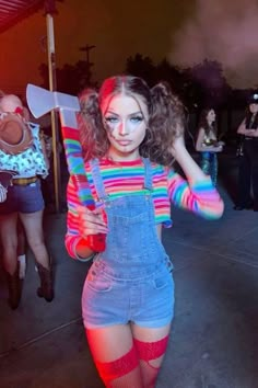 a woman in overalls and colorful makeup