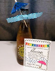 a bottle filled with liquid sitting on top of a table next to a card and umbrella