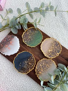 four leaf shaped cookies sitting on top of a wooden board next to a green plant