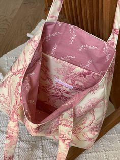 a pink and white bag sitting on top of a wooden chair