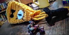 two crocheted items sitting on top of a wooden table next to each other