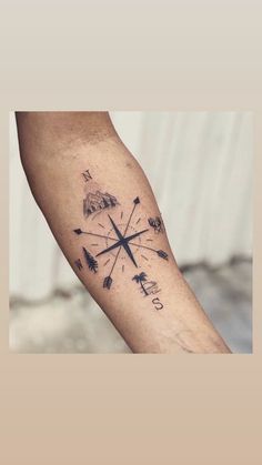 a man's arm with an arrow and compass tattoo on the left side of his arm