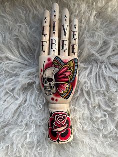 a hand painted with flowers and skulls on it