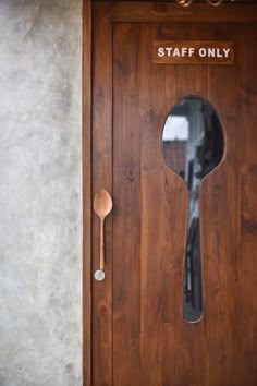 a wooden door with a spoon and mirror on the front side that says staff only