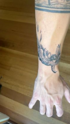 a person's arm with a bird tattoo on it