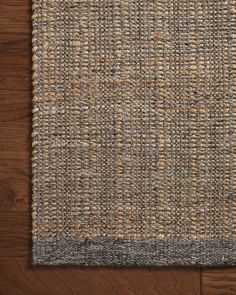 an area rug on top of a wooden floor with a brown and gray color scheme