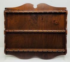 a wooden shelf with three shelves on each side and two holes in the middle for storing items