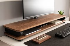 a flat screen tv sitting on top of a wooden shelf next to a keyboard and mouse