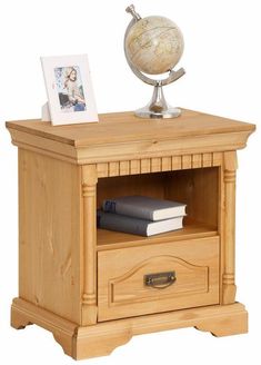 a wooden night stand with an open drawer and a globe on top, sitting next to a bookshelf