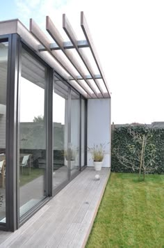 an outdoor patio with sliding glass doors and wooden decking on the side of it