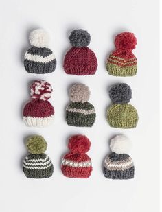 knitted hats are arranged in rows on a white surface