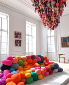 a room filled with lots of different colored balls hanging from the ceiling next to windows