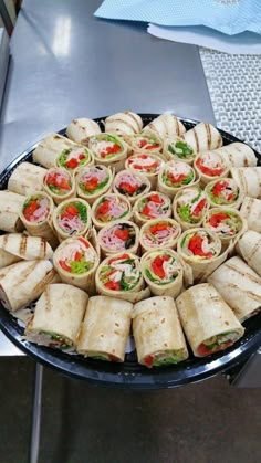 a platter filled with sandwiches on top of a table