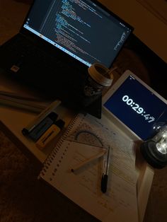 an open laptop computer sitting on top of a desk next to a calculator