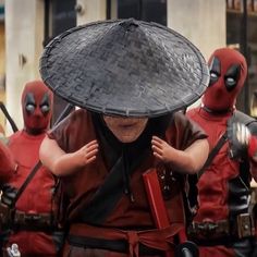 a group of deadpools dressed in costumes and hats, with one person covering his face