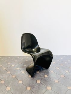 a black chair sitting on top of a tiled floor