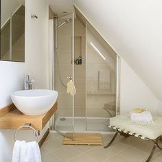 a bathroom with a sink, mirror and shower stall in the corner next to it