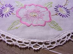 a close up of a piece of cloth with flowers on it and crocheted lace