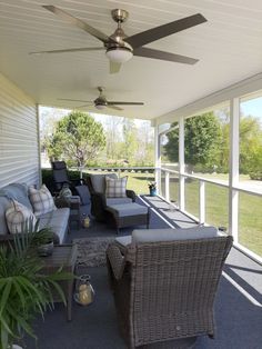 a covered porch with wicker furniture and ceiling fan