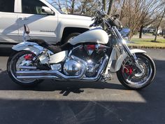 a white motorcycle parked in front of a truck