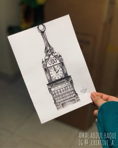 a person holding up a drawing of the big ben clock tower in london, england