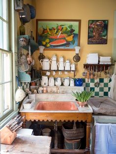 a kitchen filled with lots of pots and pans on top of a counter next to a window